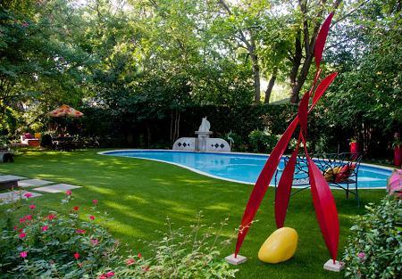 O frumoasa gradina cu obiecte de decor colorate si o piscina cu linii curbe