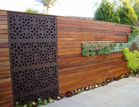 Panou decorativ metalic perforat integrat intr-un gard de lemn