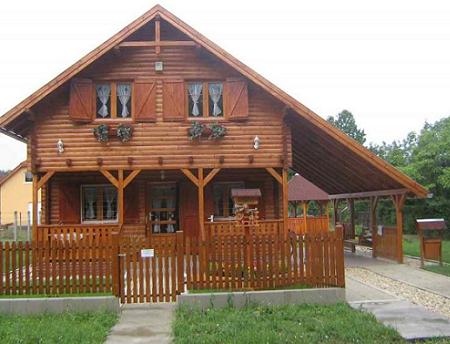 Casa din lemn cu pridvor, pavilion si obloane din lemn