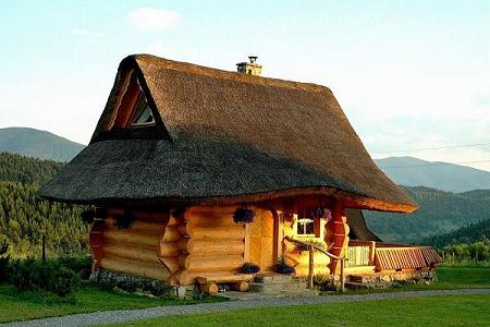 Casa construita din busteni rotunzi cu acoperis din stuf ce pare desprinsa din lumea povestilor