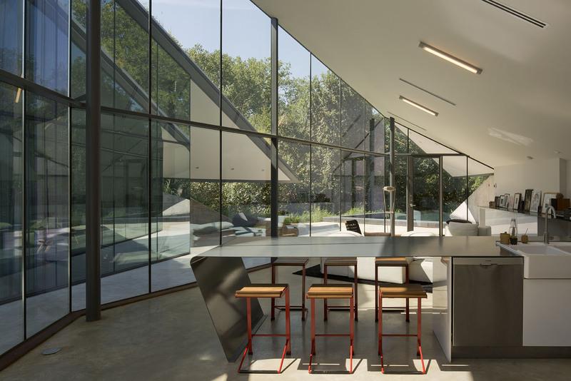 Sufrageria unei case seiingropate cu un spectaculos perete de sticla. 