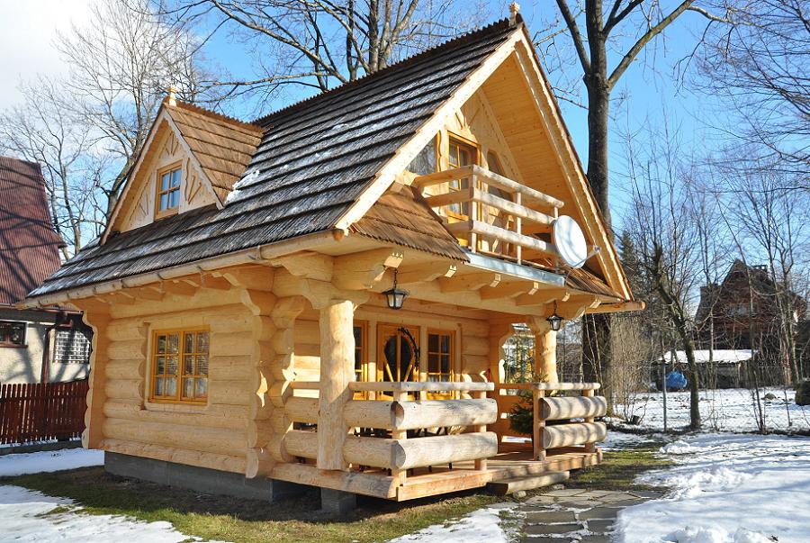 Casa din busteni rotunzi si semirotunzi cu pridvor si dormitoare la mansarda