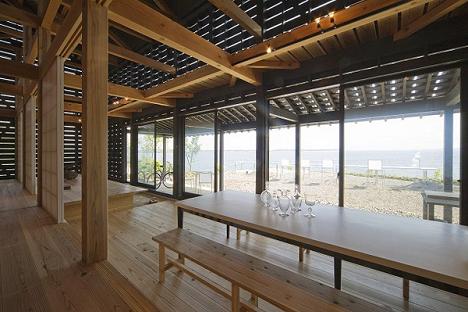 Casa cu pereti de sticla acoperiti de panouri din lemn